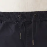 Short de gabardina azul marino, corte jogger, con puño en el ruedo, pretina elástica ajustable con cordón y bolsillos laterales.