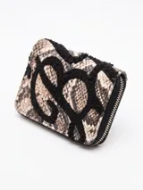 Billetera pequeña con cierre perimetral, confeccionada en material con estampado de piel de serpiente y detalle de bordado en relieve de color negro.