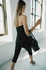 Pantalón capri negro de tiro medio y corte ajustado, confeccionado en tejido elástico con cintura elástica.