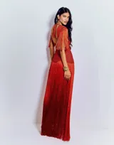 Vestido largo de crochet color rojo, con escote en V profundo, espalda descubierta y diseño ajustado en la cintura. Presenta detalles de tejido calado y una falda con flecos largos en capas que aportan movimiento.