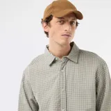 Camisa de manga larga con diseño de cuadros en tonos verde kaki y blanco, de corte recto y cierre frontal de botones.