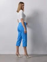 Pantalón capri blanco de gabardina elastizada. Pretina ancha elastizada, delantera con bolsillos simulados y trasera con bolsillos aplicados.