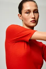 Remera roja de manga corta, confeccionada en tejido acanalado con cuello redondo.