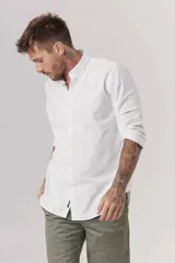 Camisa de hombre color crema, de corte clásico, con cuello abotonado y mangas largas.