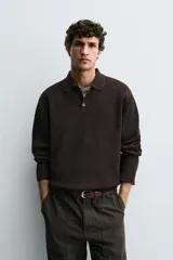 Polo de punto con textura, corte regular fit, cuello solapa con cierre frontal de tres botones, manga larga y acabados en rib.