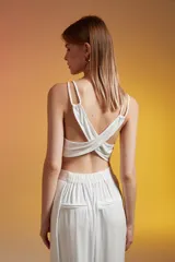 Top corto color crudo, con breteles finos y escote redondo.