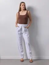Pantalón blanco de lino con lazo en la cintura, corte recto y bolsillos laterales.