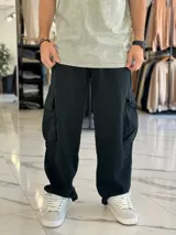 Pantalón cargo de jean negro, de corte super baggy y estilo oversize, con bolsillos laterales en los muslos.