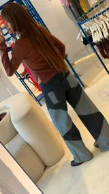 Jean de corte recto y tiro medio, confeccionado en denim con diseño de recortes geométricos en forma de rombos que generan un contraste de tonos entre negro y azul lavado.