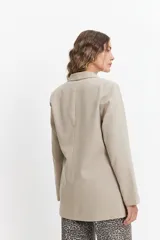 Blazer color beige estilo lino, de corte recto y largo a la cadera.