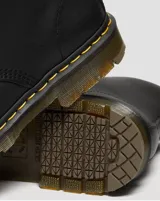 Botas de caña alta Dr. Martens modelo 1460, color negro, confeccionadas en cuero de plena flor con diseño de ocho ojales, cordones negros y suela gruesa con costuras amarillas características de la marca.