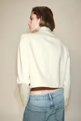 Blazer de cuello alto y manga larga con bajo asimétrico y cierre frontal cruzado con botón dorado.