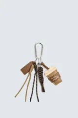 Llavero con mosquetón metálico que incluye diversos colgantes: una etiqueta de cuero sintético, cordones de distintos colores y texturas, una tira trenzada y un dije en forma de vaso de café con la inscripción 'morning coffee'.