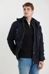 Campera de abrigo estilo parka, color verde militar, con capucha desmontable, cierre frontal con botones y múltiples bolsillos funcionales en pecho, cintura y manga.