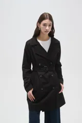 Trinchera de corte clásico, color negro, con cierre frontal de doble botonadura, solapas amplias y cinturón ajustable con hebilla en la cintura.