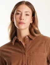 Camisa de pana marca Dash, color violeta, con cuello clásico, cierre frontal de botones y un bolsillo aplicado en el pecho.