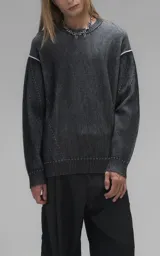 Sweater de cuello redondo con diseño de tejido acanalado vertical en color negro. Presenta detalles de costuras en contraste blanco en los hombros y en el ruedo, con un corte holgado y terminaciones en punto rib.