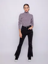 Polera de tejido con estampado geométrico en tonos rosa, negro y blanco. Es de manga larga y con cuello alto.