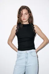 Top negro de punto rib con cuello halter, sin mangas y detalles de encaje a tono en las sisas.