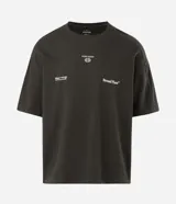 Remera de corte oversized color verde oscuro, con cuello redondo y mangas cortas. Presenta un diseño estampado en la espalda con tipografía en blanco y un pequeño logo gráfico en la parte inferior.