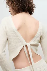 Blusa color crema de punto 100% algodón, con cuello redondo y mangas largas acampanadas.