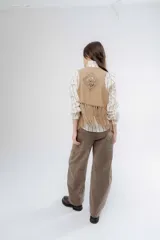 Chaleco negro de estilo boho, confeccionado en semigamuza con detalles de tejido de punto en el frente y la espalda. Presenta un diseño sin mangas con flecos en el ruedo, aportando movimiento y textura a la prenda.