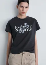 Camiseta de algodón color gris oscuro, con cuello redondo, mangas cortas y estampa frontal con la frase 'EVOLVE & GROW' acompañada de ilustraciones de mariposas.