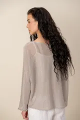 Sweater de tejido semitransparente color marrón con brillo dorado, cuello bote y mangas largas de corte holgado.