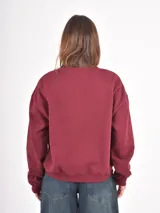 Buzo de cuello redondo en color bordó con estampado frontal en blanco que incluye el texto Brooklyn 11208 New York. Presenta un diseño de corte holgado con hombros caídos y puños acanalados.