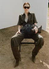 Mono largo verde militar de mezcla de lino y lyocell, con diseño recto, cuello camisero, manga corta y bolsillos laterales. Incluye cierre frontal con botones y cinturón ancho con hebilla metálica.