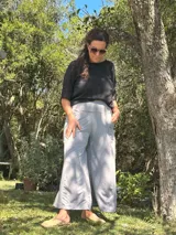 Conjunto compuesto por una blusa negra de corte holgado y mangas cortas, y un pantalón palazzo gris de tiro alto con faja ancha en la cintura y bolsillos laterales.