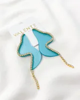 Aros colgantes de acrílico celeste con forma irregular y borde de strass dorados.