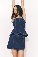 Minifalda de jean azul con corte evasé, tiro alto y cierre lateral oculto con corchete.