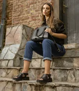 Sandalia de cuero vacuno color negro, con suela de goma deportiva, hebilla al tobillo y horma ancha.