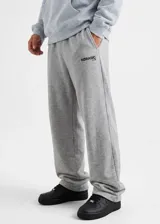 Pantalón de jogging gris melange, de corte holgado y diseño baggy. Cuenta con bolsillos laterales y el logo impreso en la pierna izquierda.