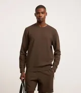 Buzo deportivo de manga larga color marrón, con cuello redondo y etiqueta aplicada. Confeccionado en tejido de poliéster, viscosa y elastano, de secado ultrarrápido, ligero y cómodo.