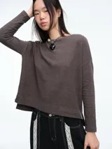 Buzo tejido de punto con diseño de rayas horizontales, cuello redondo y calce holgado con tajos laterales.