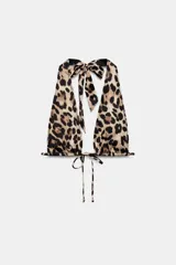 Top de bikini tipo cortinilla con estampado animal print, escote en pico y tirantes multiposición que se anudan al cuello y en la espalda.