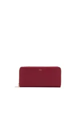 Billetera rectangular de color bordó con textura saffiano, cierre perimetral con cremallera metálica dorada y logo de la marca grabado en el frente.