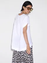 Remera blanca de lino con corte asimétrico y mangas cortas.
