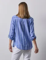 Camisa de lino marca Dash, color beige con rayas verticales blancas, cuello con solapa, cierre frontal de botones, bolsillo aplicado en el pecho y mangas largas con sistema para arremangar mediante presilla y botón.