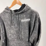 Canguro gris con efecto lavado, corte oversize y estampa en el frente con la frase "Growing Like a Flower" y un diseño de una flor en verde y blanco.