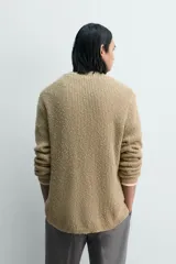 Jersey de punto con calce relajado, cuello pico y manga larga. Tejido en hilatura con textura irregular, mezcla de algodón y lino.
