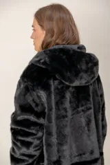 Tapado reversible de corte recto con capucha. Un lado presenta un acabado de piel sintética negra de pelo corto, mientras que el otro lado es de tela técnica lisa en color gris oscuro. Cuenta con cierre frontal y mangas largas.