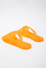 Sandalia chata de goma semi transparente color gris, con doble tira entrelazada sobre el empeine.