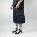 Bermuda negra de jean con corte amplio, bolsillos laterales tipo cargo y largo a la rodilla.