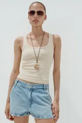 Shorts de denim de tiro medio, color celeste claro lavado, con trabillas, bolsillos laterales y bolsillos de plastrón en la espalda. Cierre frontal con cremallera y botón metálico.