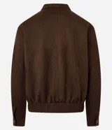 Campera masculina de estilo casual con cuello inglés, cierre frontal por cremallera, bolsillos laterales y ajuste elástico en el bajo. Presenta detalles de recortes en la parte superior delantera.