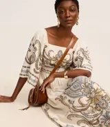 Vestido evasê midi confeccionado en viscolino, con mangas amplias, escote cuadrado en el busto y en la espalda, recorte en la cintura, lastex en la espalda y estampa de arabescos con estilo étnico en el tronco, mangas y en la bajo.