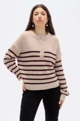 Sweater de tejido de punto con diseño de rayas horizontales en color bordó sobre base beige. Presenta cuello redondo a la base con cierre frontal de tres botones y mangas largas con corte holgado.